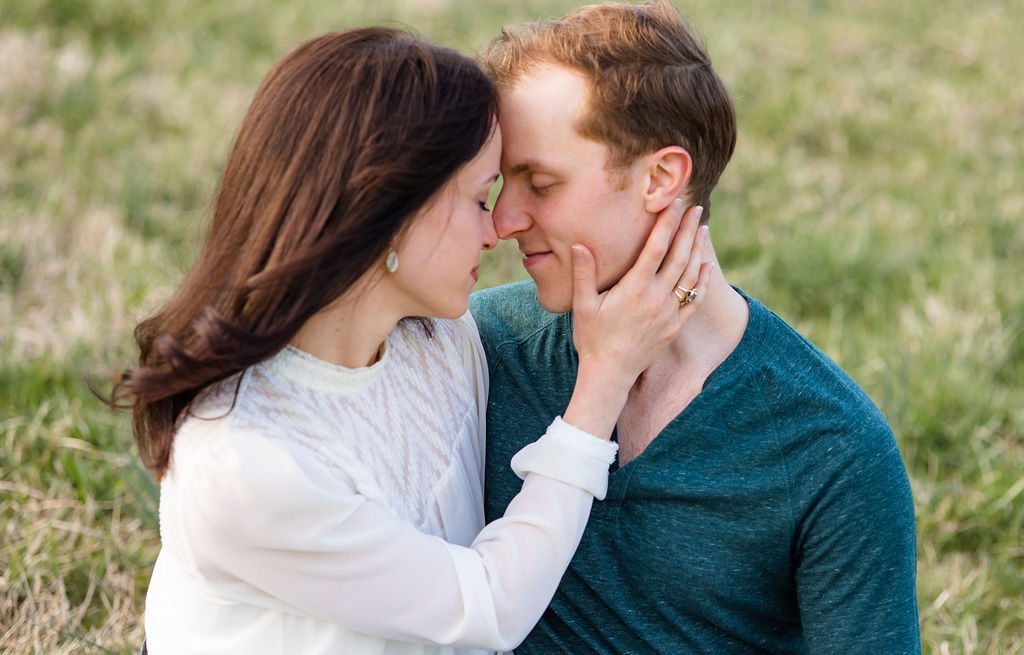 Girl and Guy forehead to forehead with eyes closed to soak in the moment of being engaged and taking their engagement photos