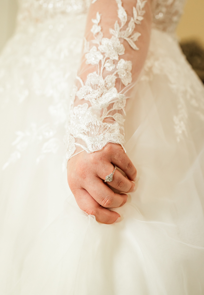 Bride clutching onto the fabric of her wedding dress.