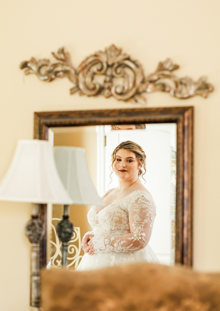 Creative reflection of bride in the mirror of Annabella at Cedar Glen's bridal suite.