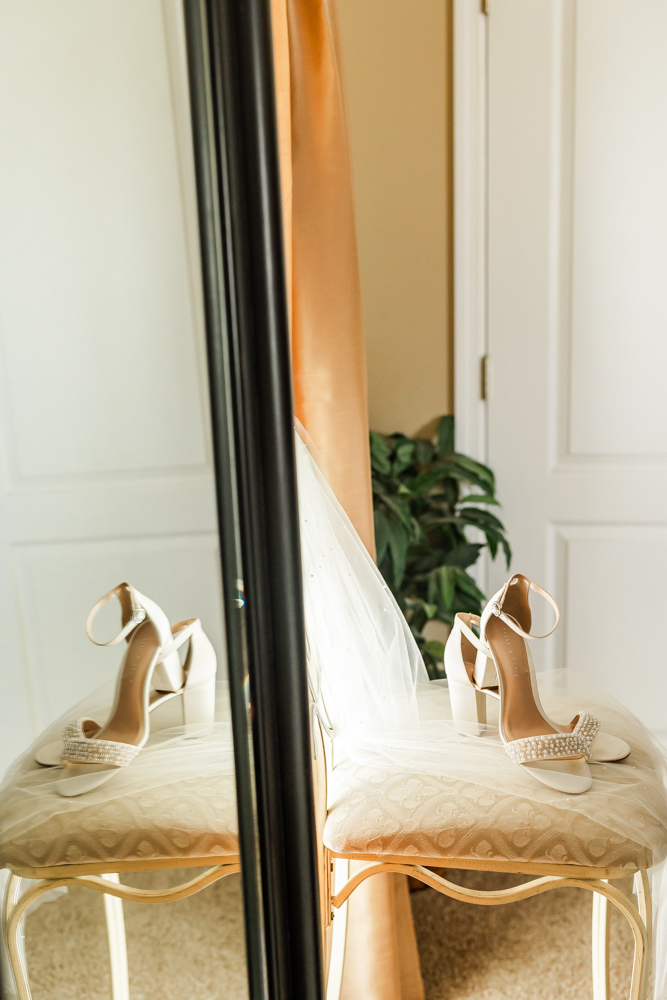 Bridal shoes and veil resting on a stool at the beginning of the wedding day