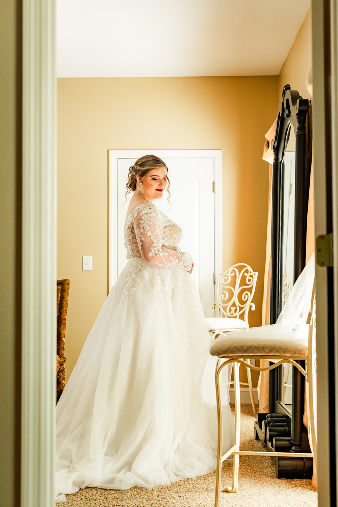 View of the bride through the doorway of the bridal suite at Huntsville wedding venue, Annabella at Cedar Glen.