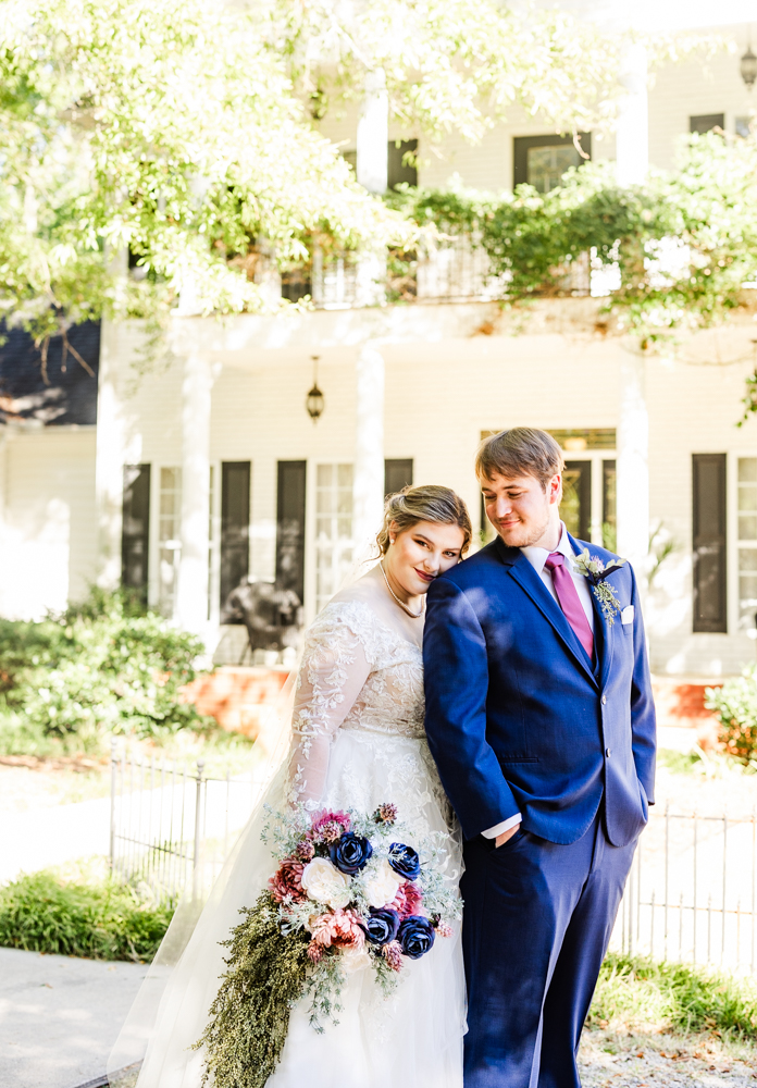 Groom gazing over his right shoulder to peer at his bride.