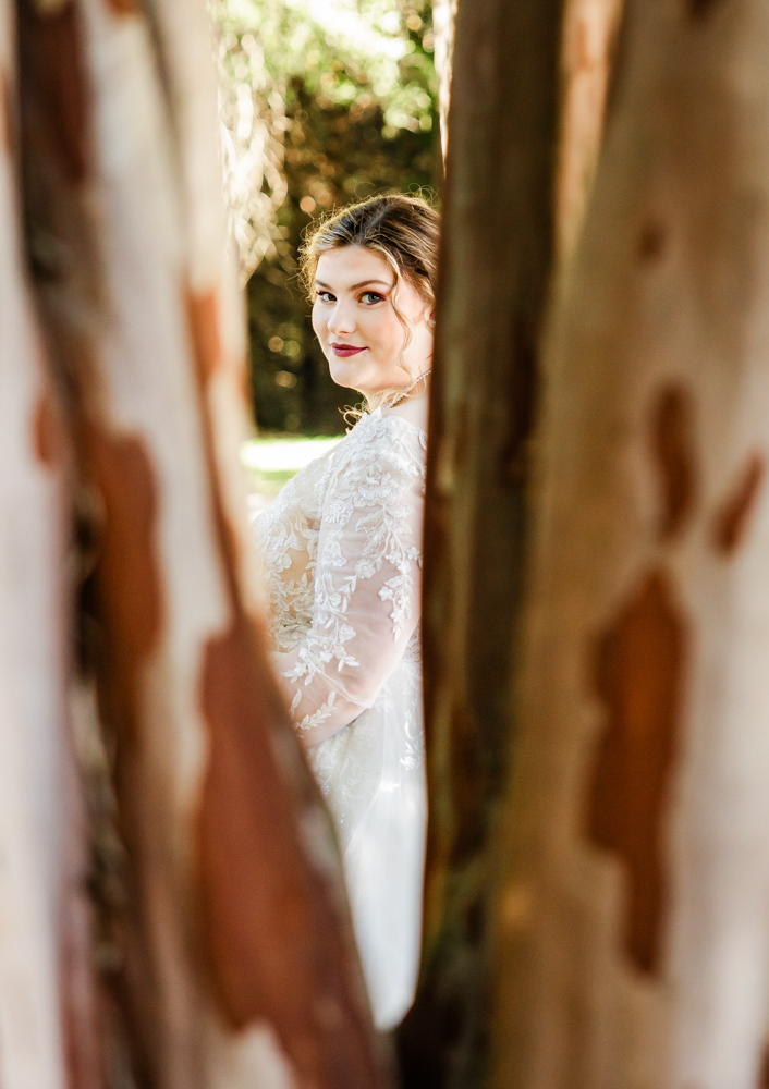 Portrait of bride through the trees on the front lawn of Annabella at Cedar Glen.