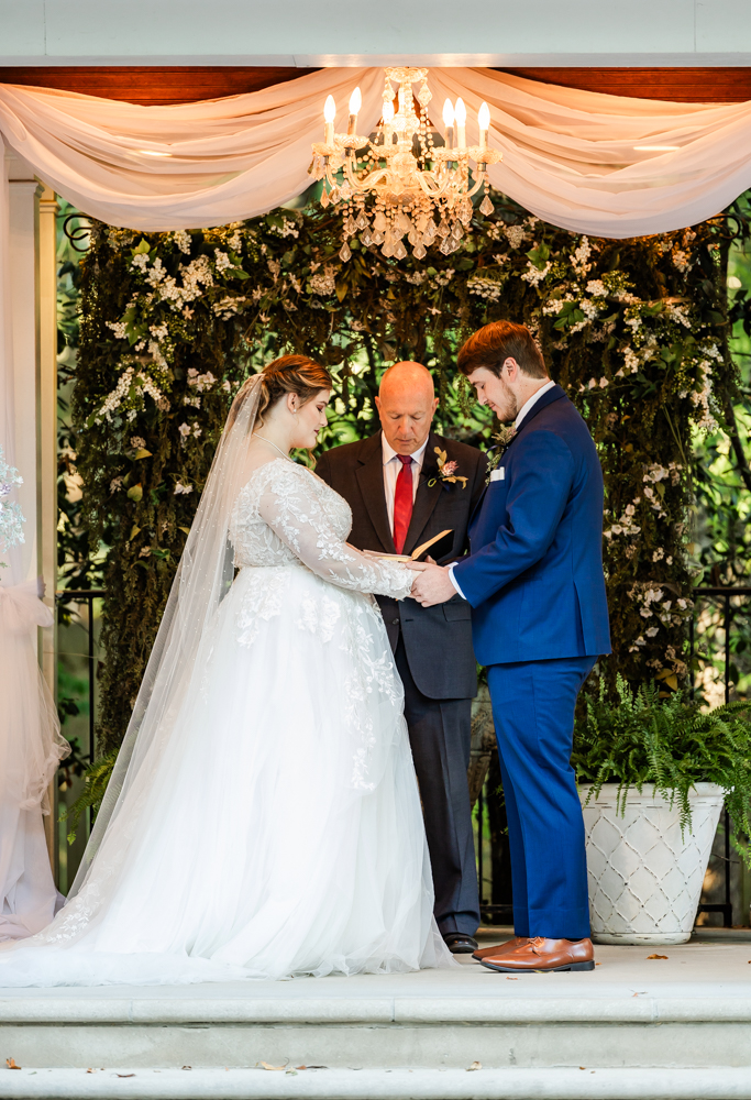 Bride and groom with bowed heads while they are prayed over during their Huntsville wedding ceremony