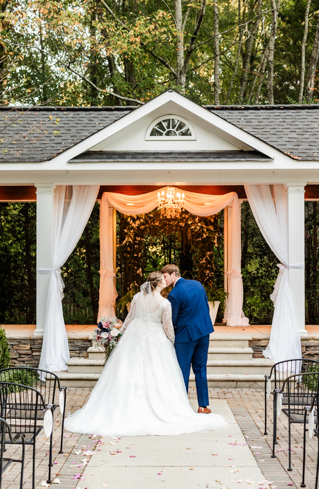 Newlywed portraits in the outdoor ceremony space of a Huntsville wedding venue.