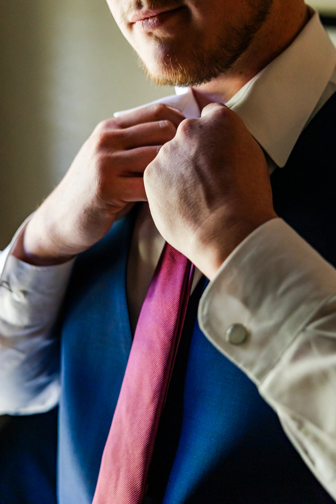 Groom adjusting his tie in the groom's suite at Annabella at Cedar Glen.