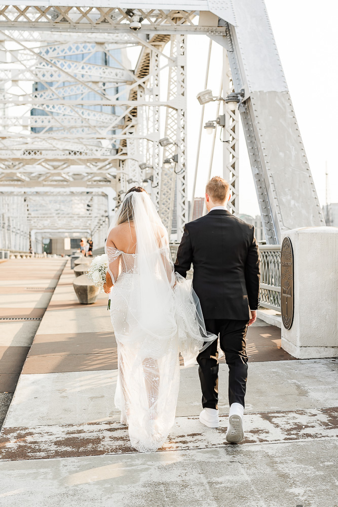 Newlyweds walking across the Pedestrian Bridge in Nashville, TN