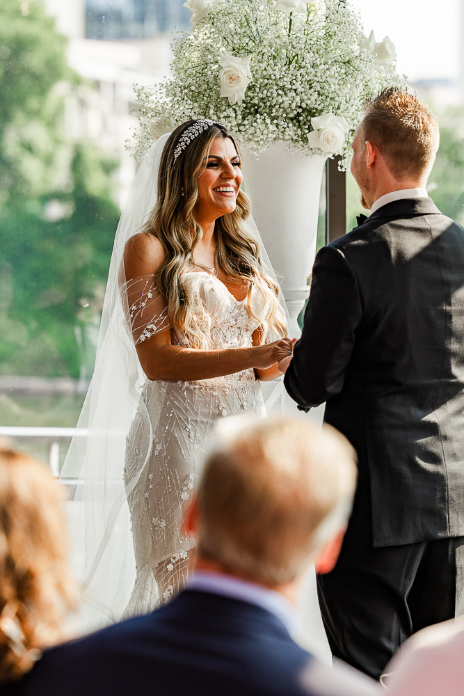 The Bridge Building bride smiling at her groom during the wedding ceremony