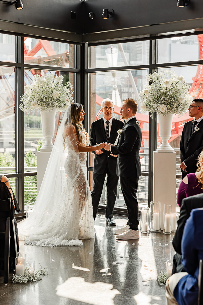 The Bridge Building bride and groom holding hands during wedding ceremony