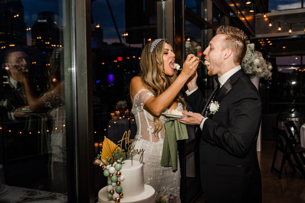 The Bridge Building bride and groom feeding each other cake