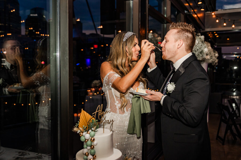 The Bridge Building bride and groom feeding each other cake