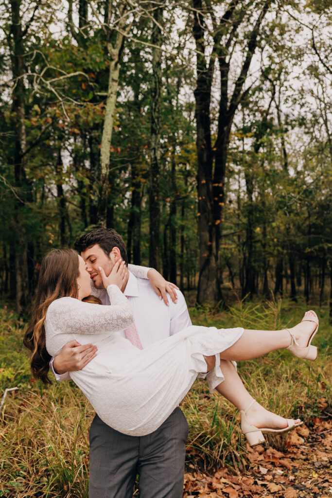 Guy carrying his fiancée on the rocky beach at Long Hunter State Park