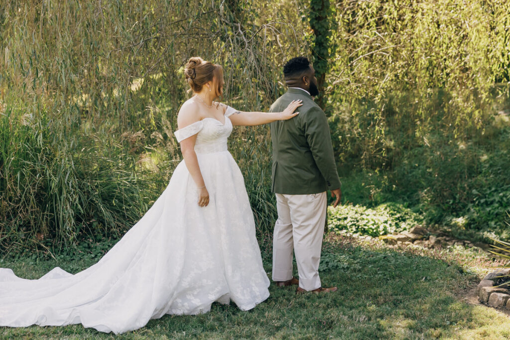 Bride tapping groom on should right before first look