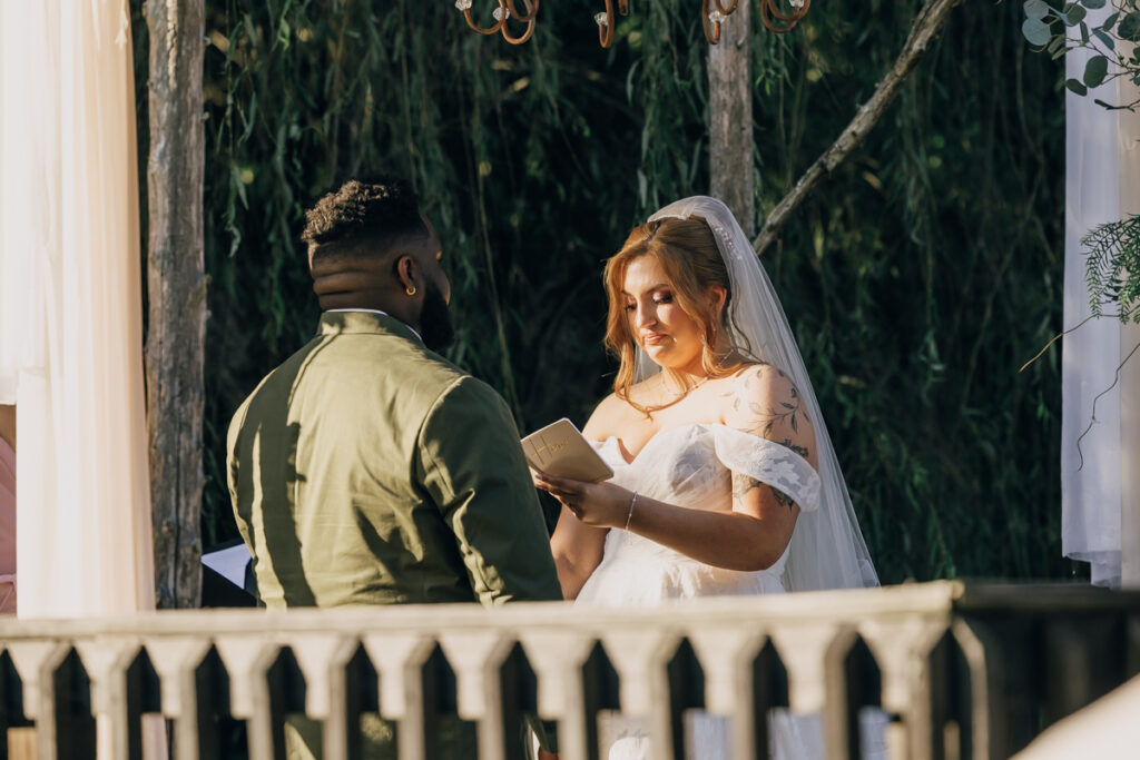 Bride reciting her vows to her groom during outdoor ceremony at Rustic Elegance