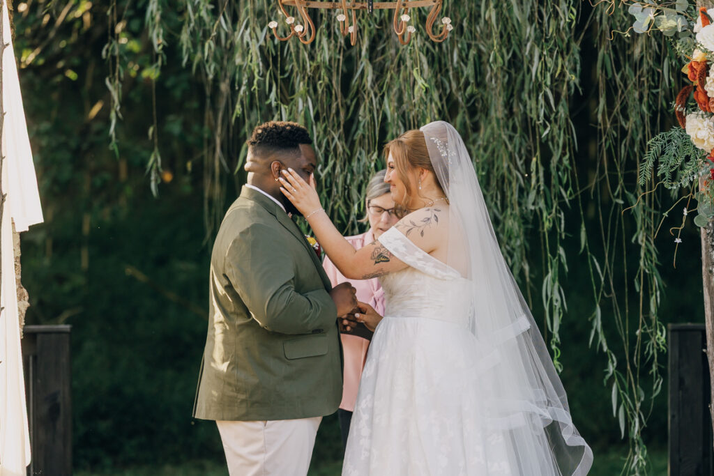Bride wiping away her soon-to-be husband's tears.