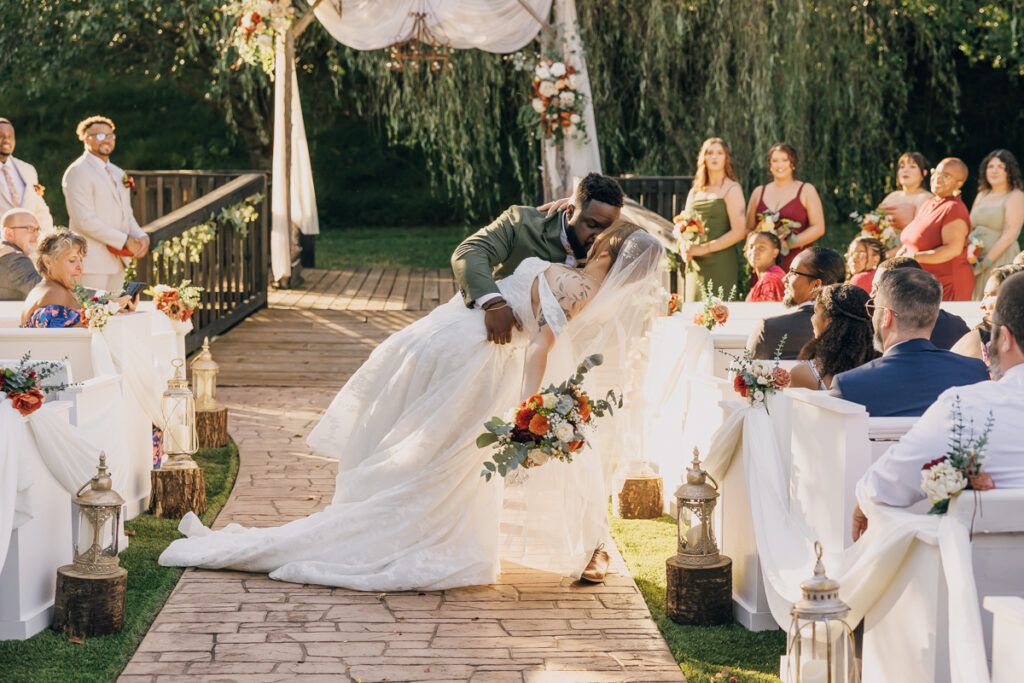 Groom joyfully dips his bride as they make their exit from the ceremony.