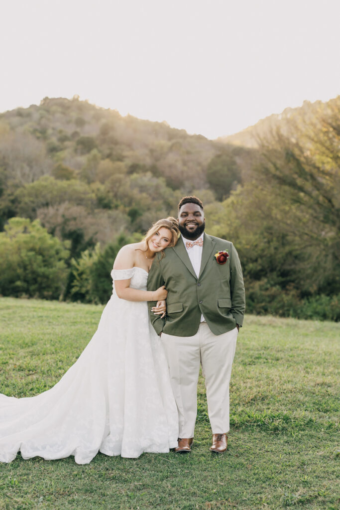 Newlyweds sharing an intimate moment as the bride leans on her husband's shoulder during portraits