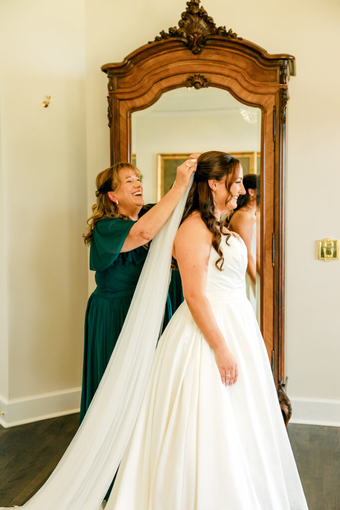 Bride getting her veil adjusted by her mother at Stone Haven wedding venue.