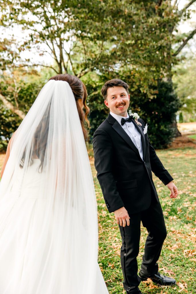 Groom seeing the bride for their first look outside the Rock House at Stone Haven.