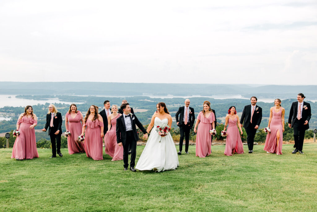 Bride and groom walking with their full wedding party.