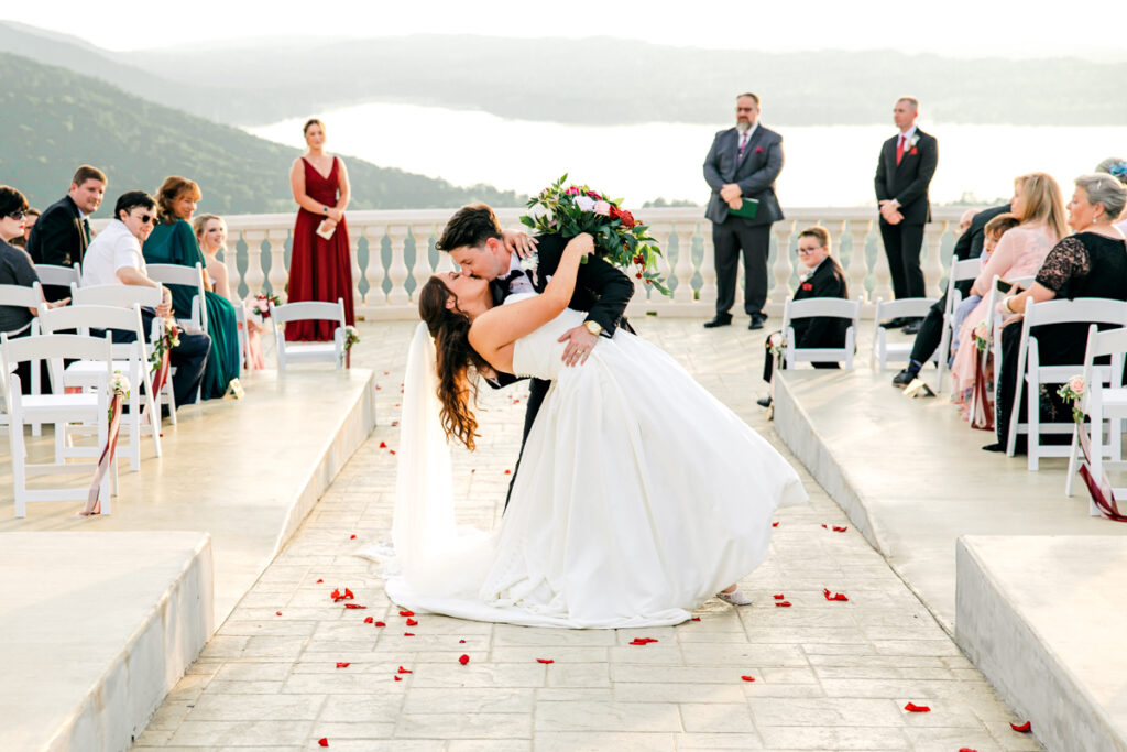 Groom dipping his bride as they walk back down the ceremony aisle.