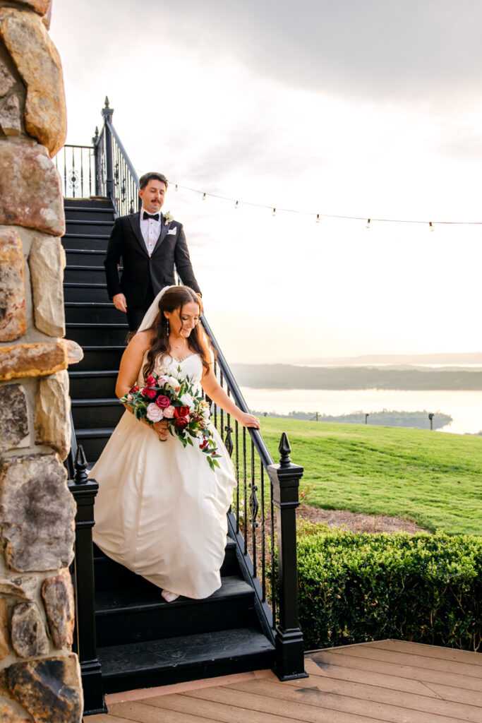 Bride and groom walking down staircase.