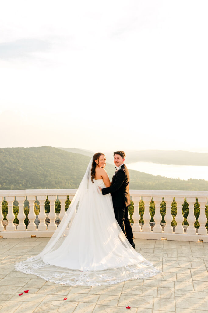 Bride and groom turning over their shoulders and smiling.