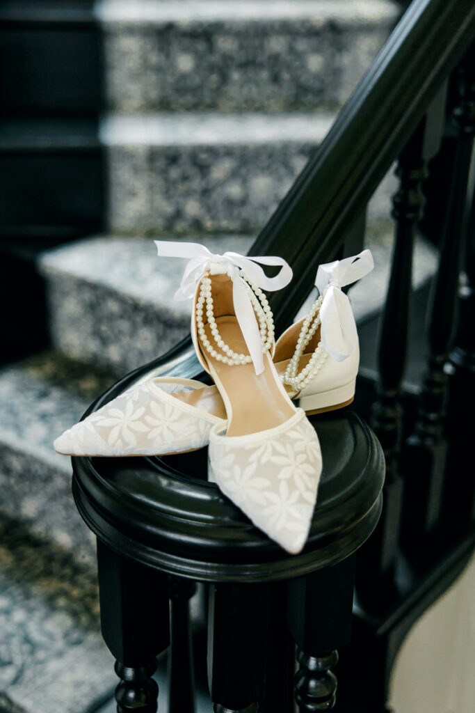 Bridal shoes sitting on the staircase banister at Stone Haven wedding venue.