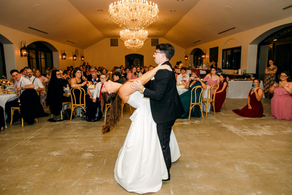 Bride dramatically arching backward during her first dance with the groom at the wedding reception.