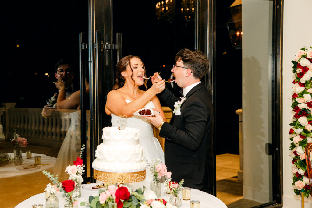 Bride and groom feeding each other wedding cake.