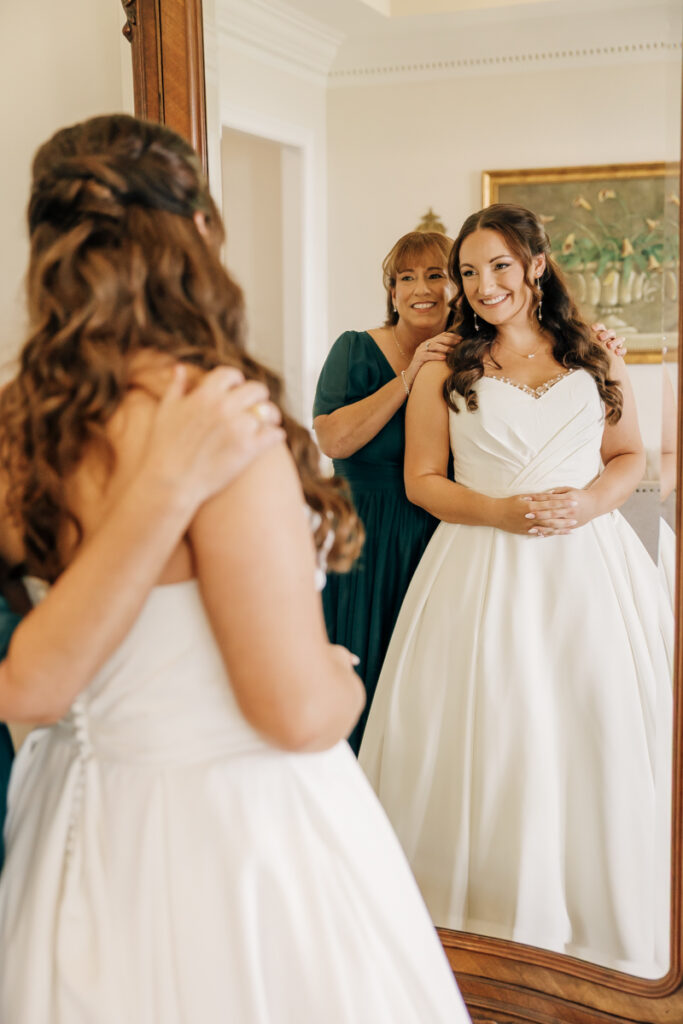 Bride and her mom embracing after she puts on her wedding dress at Stone Haven wedding