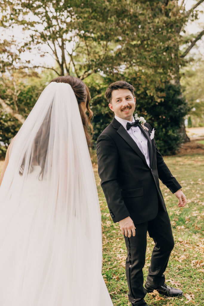 Groom seeing the bride for their first look outside the Rock House at Stone Haven.
