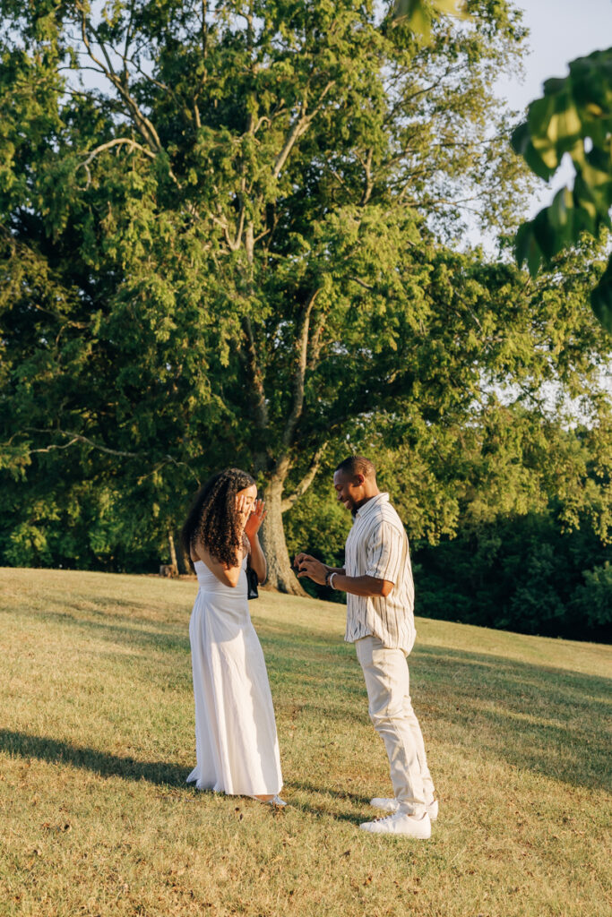 Man taking the engagement ring out of the box during proposal