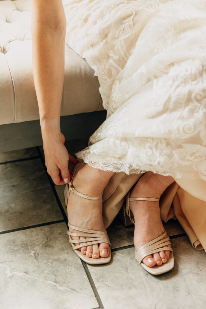Bride putting on her shoes in the bridal suite at Tayvin Gardens
