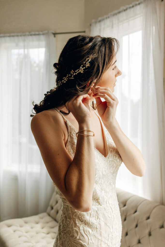 Bride putting on her jewelry in the bridal suite at Tayvin Gardens 
