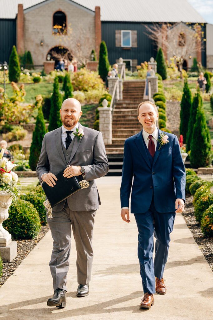 Groom and officiant walking down the aisle during ceremony at Tayvin Gardens.