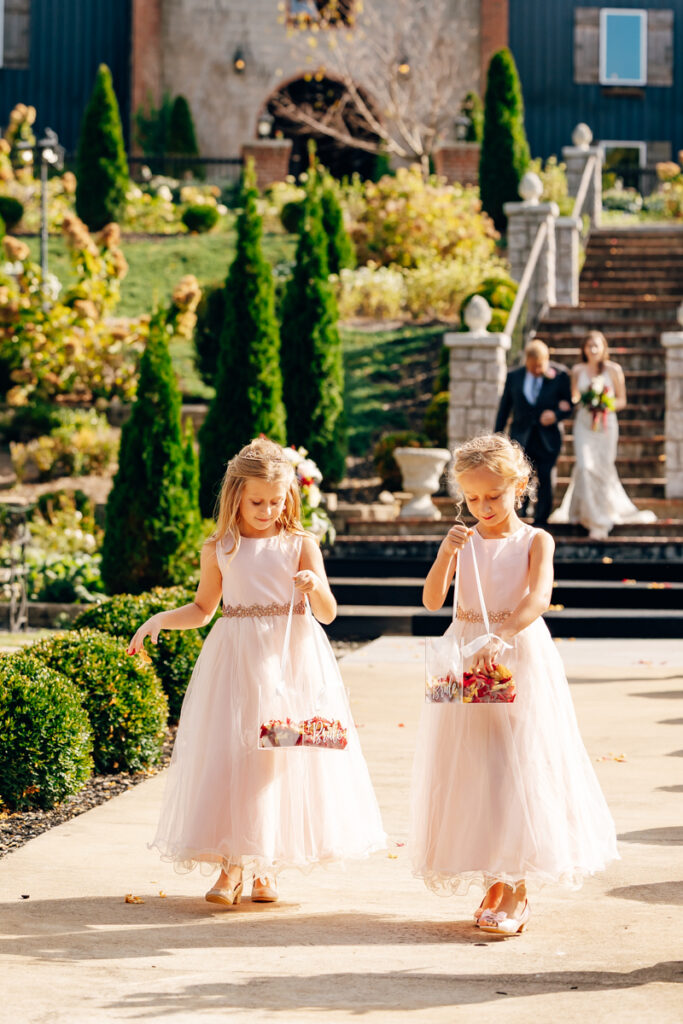 Flower girls walking down the aisle during ceremony at Tayvin Gardens.