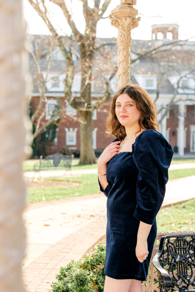 College grad leaning against gazebo post