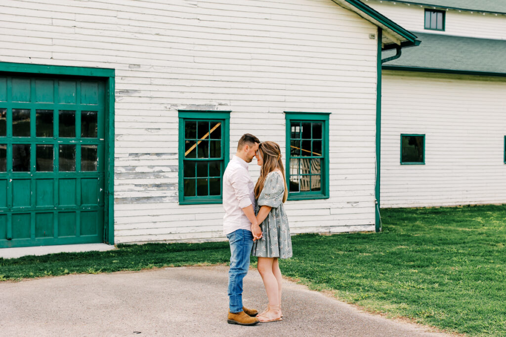 Couple standing forehead to forehead, holding hands and sharing an intimate moment