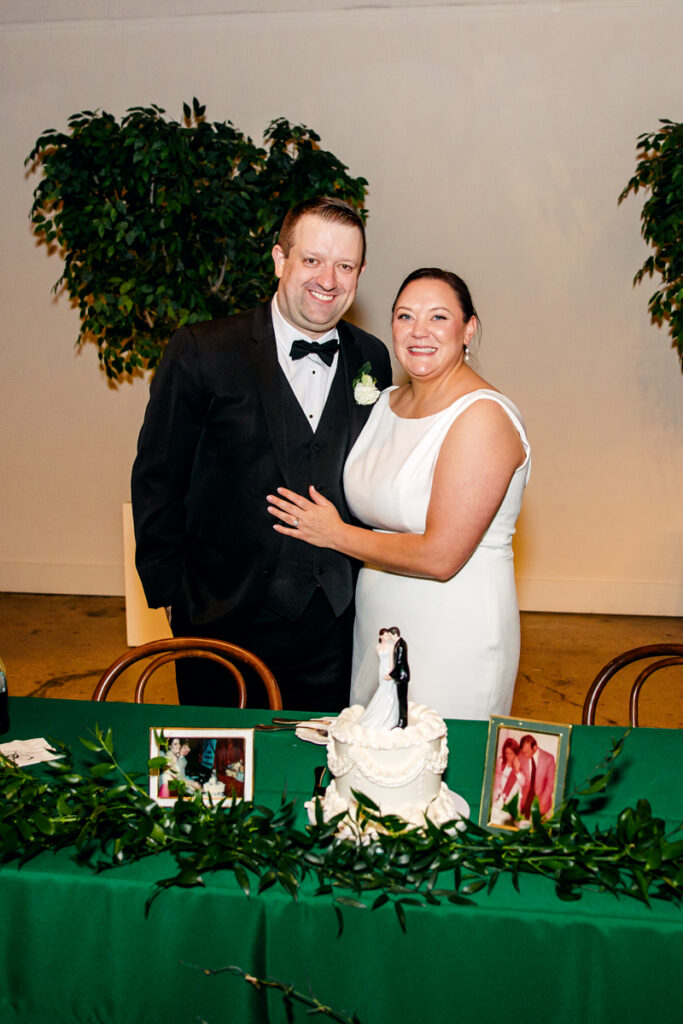 Bride and groom smiling after cutting their wedding cake at Saint Elle.