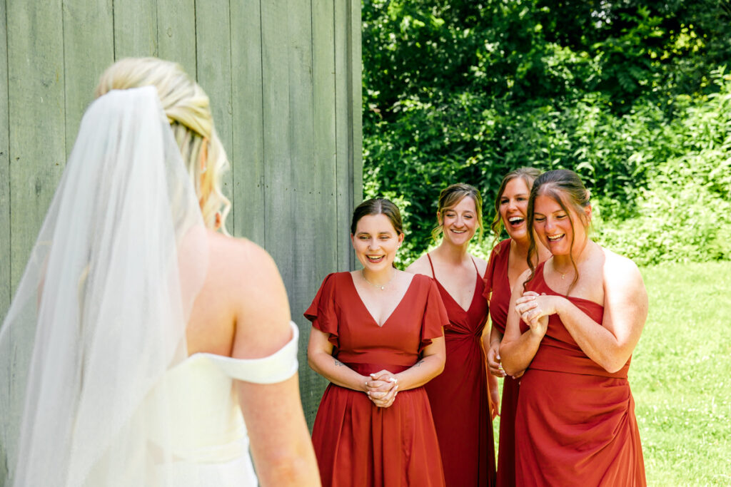 Bridesmaids reacting to seeing the bride in her dress for the first time