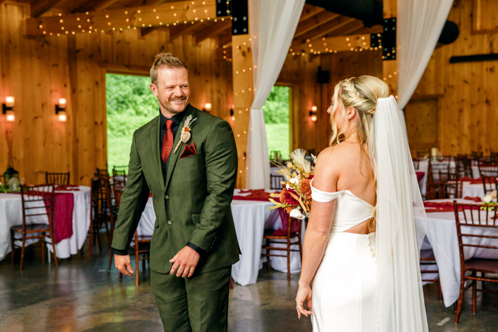 Groom joyfully seeing his bride in her wedding dress with veil and bouquet for the first time