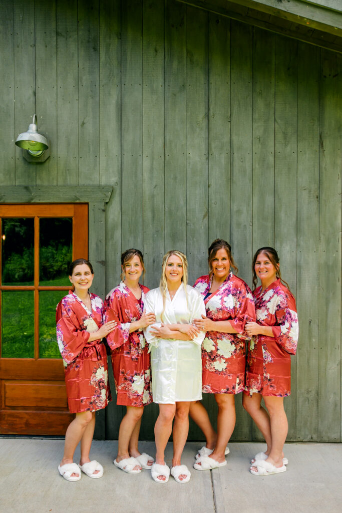Bride with her bridesmaids dressed in matching robes at 4 Points Farm