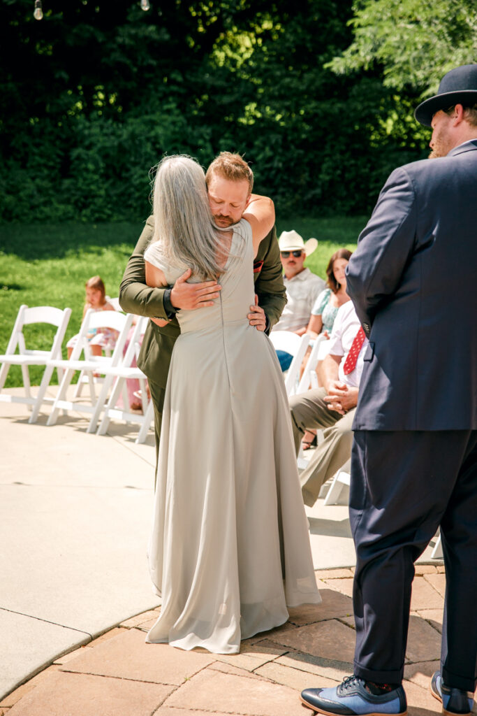 Groom hugging his mom after walking down the aisle