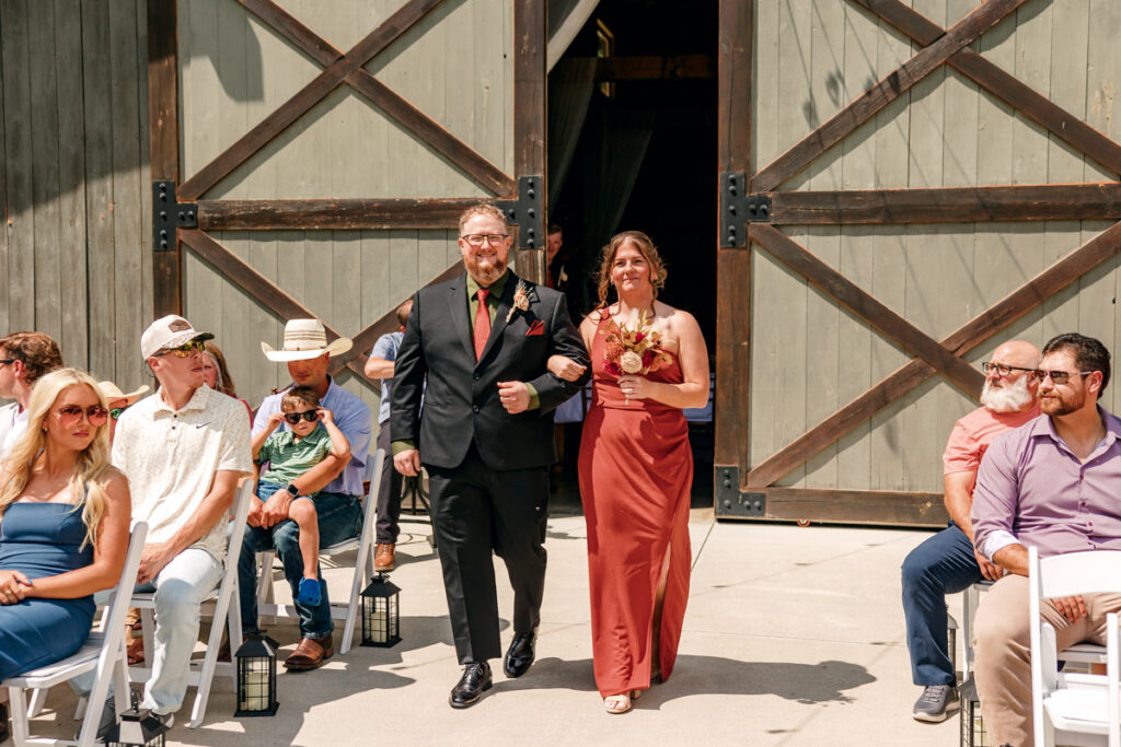 Bridesmaid and groomsman walking down the aisle during a wedding ceremony at 4 Points Farm