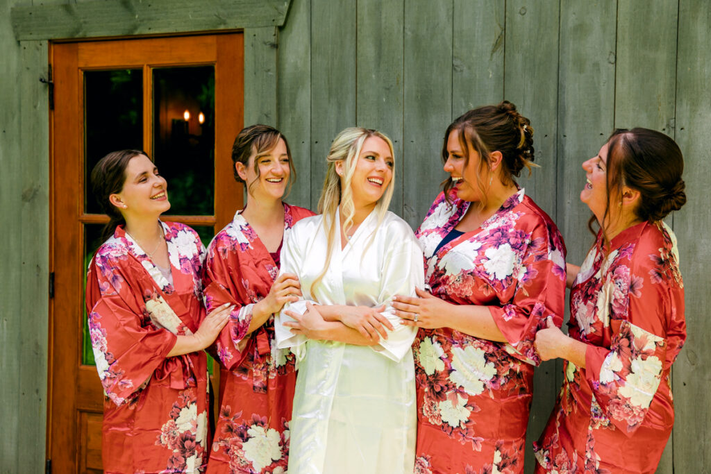Bride and bridesmaids in robes sharing a moment of laughter
