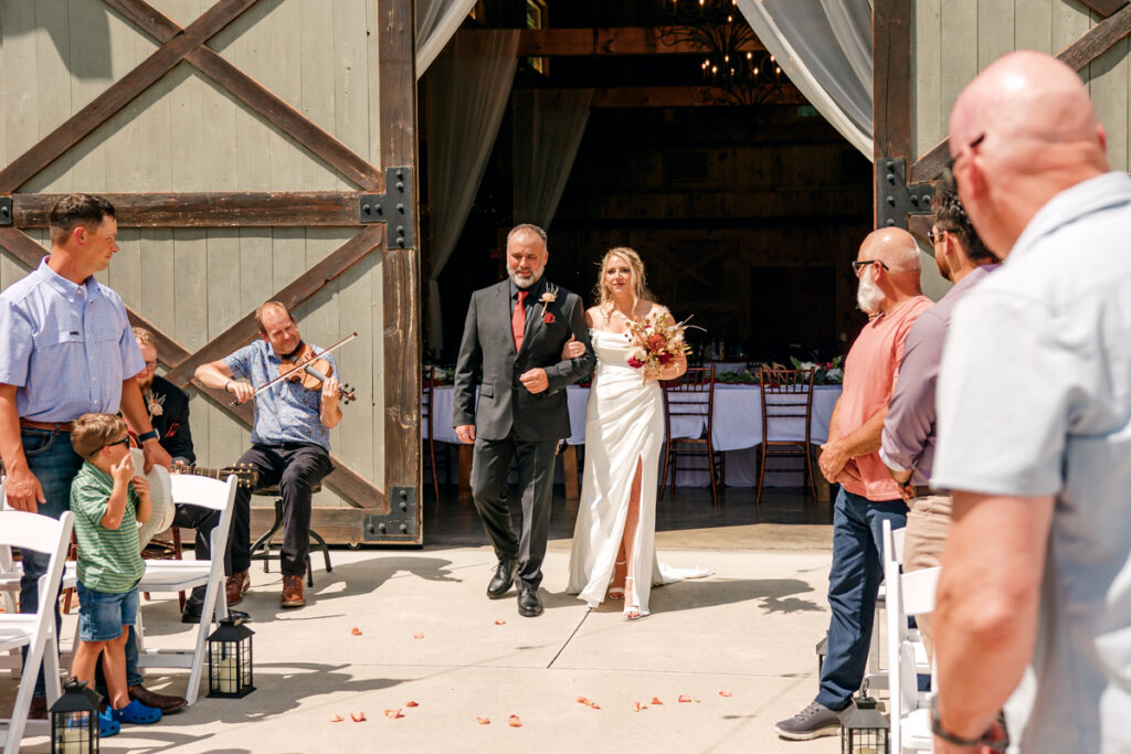 Bride walking down the aisle accompanied by her dad