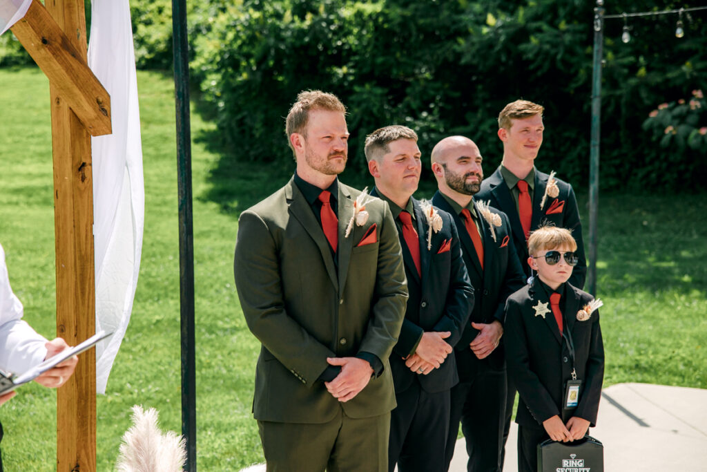 Groom gazing at his bride and she walks down the aisle
