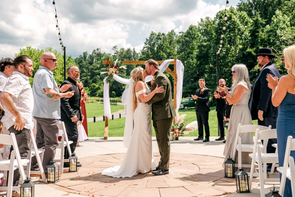 Newlyweds share a kiss while walking down the aisle after their 4 Points Farm ceremony