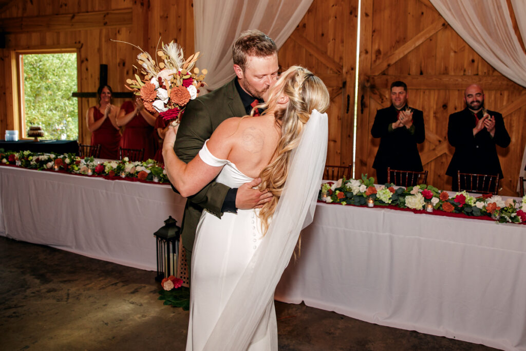 Bride and groom share a kiss after they enter into their reception